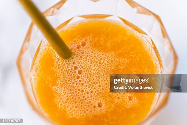 drinking glass with orange juice on a white marble table with copy space - orange juice stock pictures, royalty-free photos & images