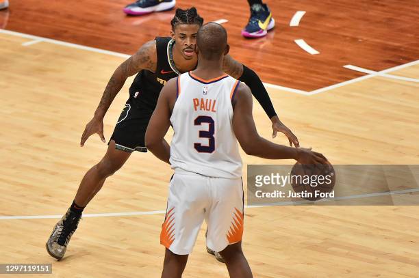 Ja Morant of the Memphis Grizzlies guards Chris Paul of the Phoenix Suns during the second half at FedExForum on January 18, 2021 in Memphis,...