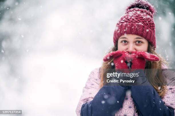 smiling woman heating up her hands - fingerless glove stock pictures, royalty-free photos & images