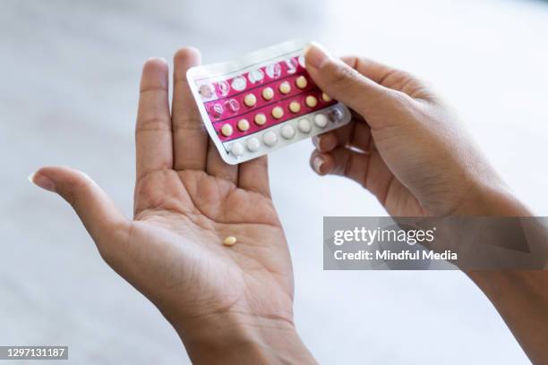 frau hält antibabypillen zu hause - tablette stock-fotos und bilder