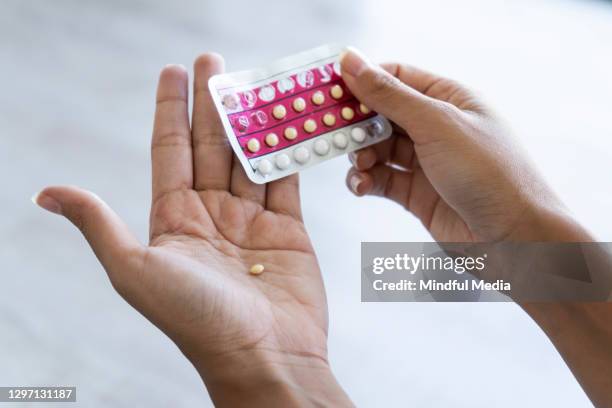 woman holding birth control pills at home - take control imagens e fotografias de stock