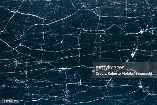 cracked ice on frozen lake silvaplana, aerial view, switzerland - ice texture stock pictures, royalty-free photos & images