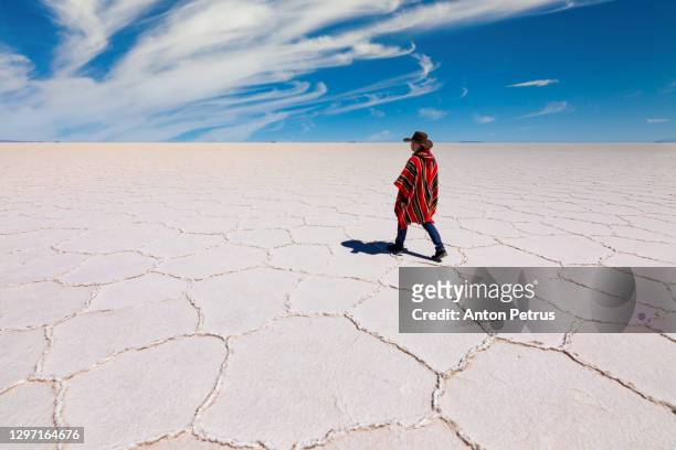 man in poncho at salar de uyuni, aitiplano, bolivia. traveling in bolivia - ポンチョ ストックフォトと画像