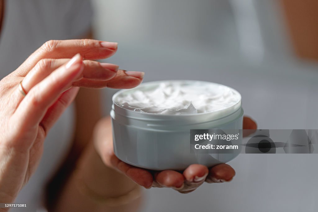 Frau mit feuchtigkeitsbefeuchtender Creme für saubere und weiche Haut