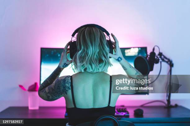 joueur féminin mettant ses écouteurs sur - joueur de jeux informatiques photos et images de collection