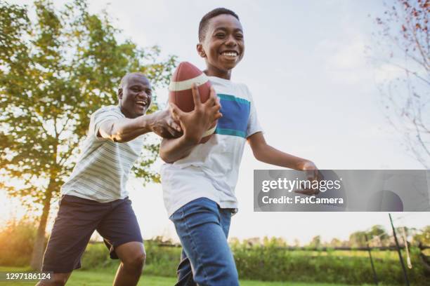 vader en zoon die binnenplaatsvoetbal spelen - family backyard stockfoto's en -beelden