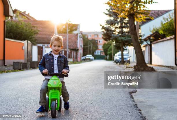 boy's ride around the neighborhood - 4 wheel motorbike stock pictures, royalty-free photos & images