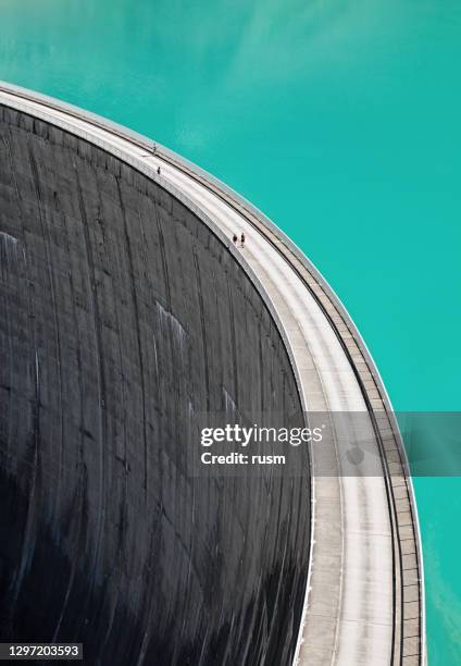 people walking on edge of stausee mooserboden dam, kaprun, austria - hydroelectric dam stock pictures, royalty-free photos & images