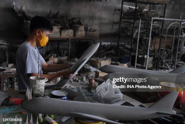 An employee works on aircraft miniatures at the Anglo Aircraft Model workshop in Cibinong, Bogor Regency, West Java, Indonesia, on November 24, 2020....