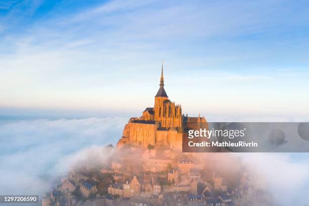 amazing light and fog over the mont saint-michel in normandy from the sky - mont saint michel stock pictures, royalty-free photos & images