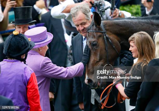 Trainer Sir Michael Stoute looks on as Queen Elizabeth II pats her horse 'Estimate' after it won the Ascot Gold Cup on day 3 'Ladies Day' of Royal...