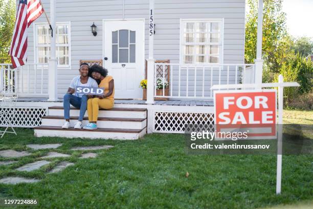 debido al colapso de las propiedades, la joven pareja afro vende su casa - estrenar casa fotografías e imágenes de stock