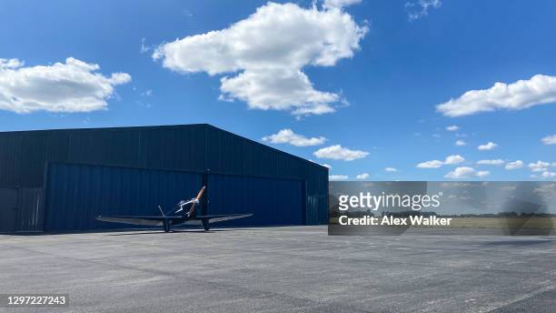 vintage single engine propeller aircraft in front of hangar - hanger stock pictures, royalty-free photos & images