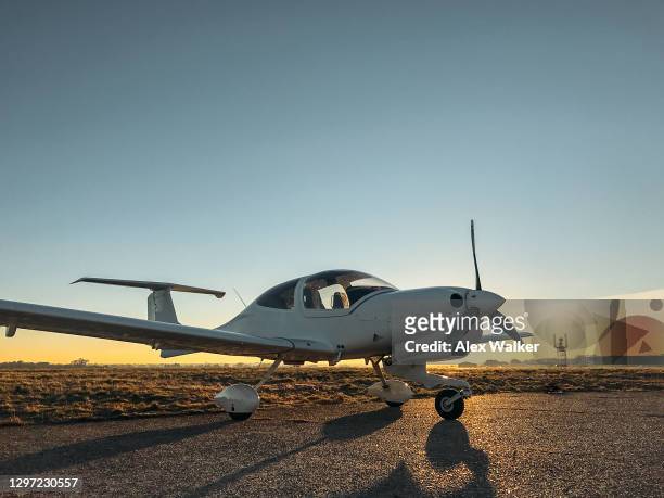 parked small single engine propeller aircraft at sunset - avião propulsor imagens e fotografias de stock