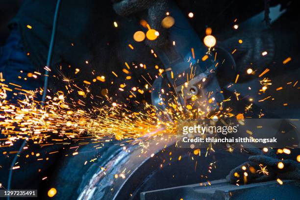 sparks from grinding on metal work - stahlindustrie stock-fotos und bilder