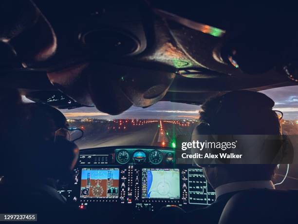 pilot in cockpit of small private aircraft landing at night. - pilot stock pictures, royalty-free photos & images