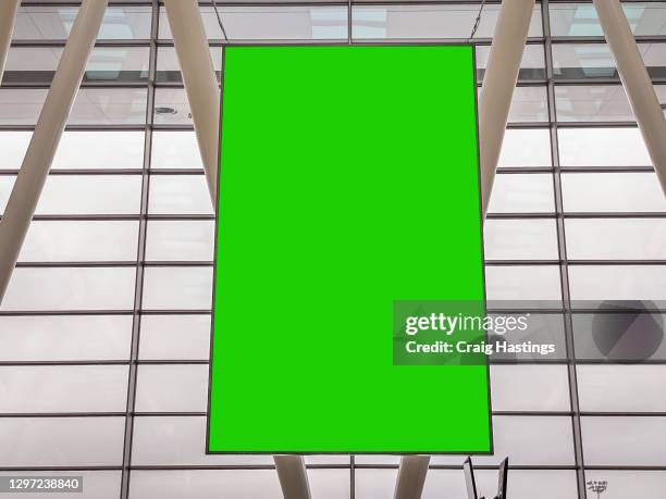 large green screen blank empty marketing billboard sign in airport departure lounge setting. - arrival gate stock pictures, royalty-free photos & images