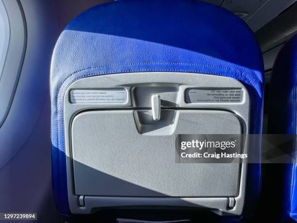 low cost economy airline tray table and window in flight on a sunny day with copy space. - siège d'avion photos et images de collection