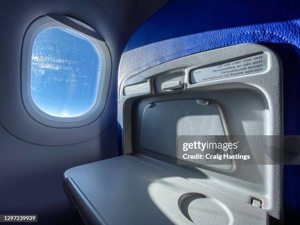 low cost economy airline tray table and window in flight on a sunny day with copy space. - 飛行機の座席 ストックフォトと画像