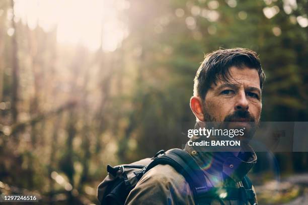 portrait of rugged handsome man looking to camera with solemn expression - macho stock pictures, royalty-free photos & images
