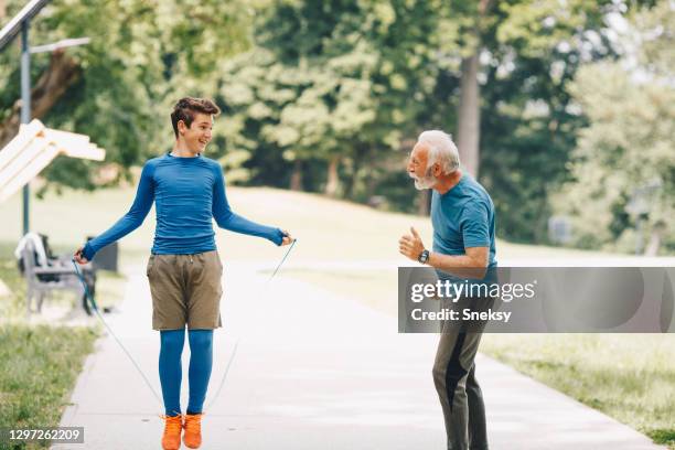 young boy is working out while his granddad is watching. - old trying to look young stock pictures, royalty-free photos & images