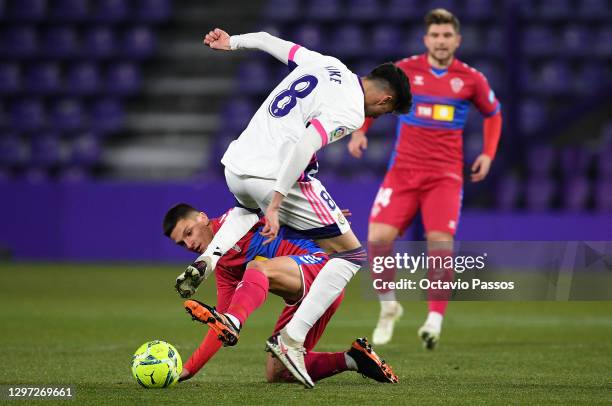 Kike Perez of Real Valladolid is tackled by Jony Alamo of Elche CF during the La Liga Santander match between Real Valladolid CF and Elche CF at...