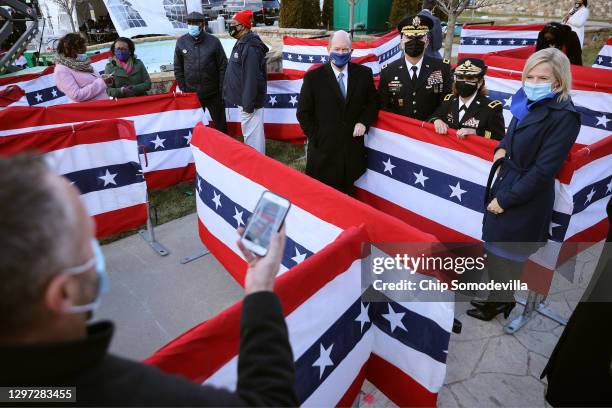 Guests, including Sen. Chris Coons pose for photographs among bunting-covered partitions to keep social distancing due to the coronavirus during a...