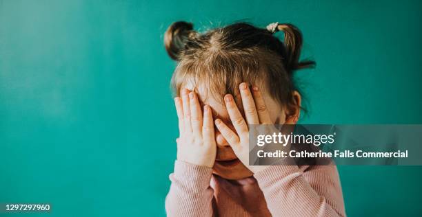 young girl covers her eyes with her hands - fobia imagens e fotografias de stock