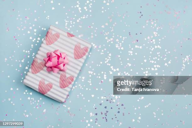 gift or present box with pink bow on pastel blue background with pink hearts confetti. wedding. birthday. happy woman's day. mother day. valentine's day. flat lay, top view, copy space. - wedding symbols stock pictures, royalty-free photos & images