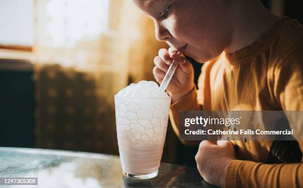 little boy blowing milk bubbles - child bubble stock-fotos und bilder