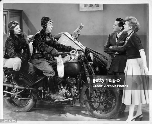 Vivian Vance and Bill Frawley ride in on a motorcycle in front of a dismayed Desi Arnaz and Lucille Ball in the television series 'I Love Lucy', 1951.