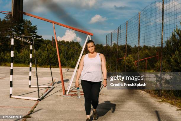 portrait of an plus size woman during a workout on an outdoor basketball court - voluptuous stock pictures, royalty-free photos & images