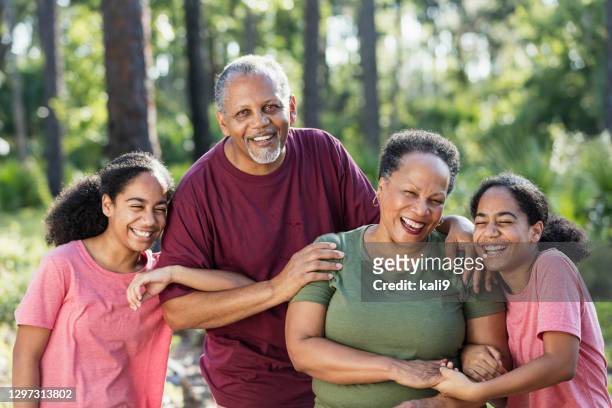 identical twin sisters with their grandparents - arm in arm stock pictures, royalty-free photos & images