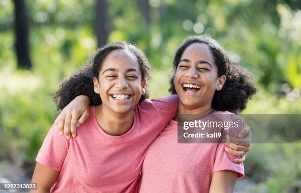 identieke tweelingzussen, afrikaans-amerikaanse tieners - eeneiige tweeling stockfoto's en -beelden