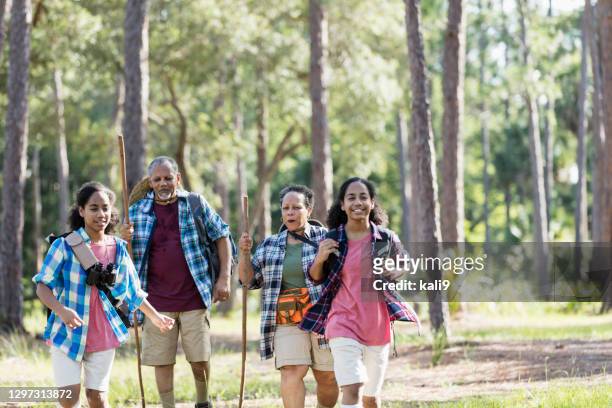 teenager-mädchen wandern im park mit ihren großeltern - four people stock-fotos und bilder