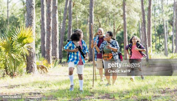ragazze adolescenti che escursionistiche nel parco con i nonni - family hiking in spring outdoors foto e immagini stock