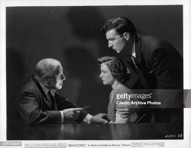 Edmund Gwenn talks to Phyllis Thaxter while Stephen McNally holds her in a scene from the film 'Bewitched', 1945.