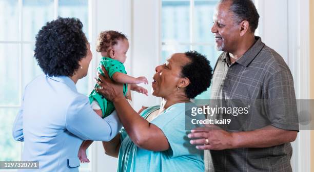 grandparents and aunt with baby inside home - grandparents raising grandchildren stock pictures, royalty-free photos & images