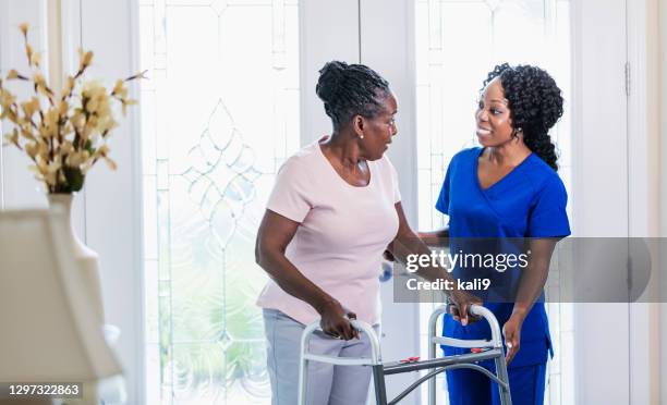 de verpleegster die van het huis hogere vrouw thuis helpt gebruikend wandelaar - looprek stockfoto's en -beelden