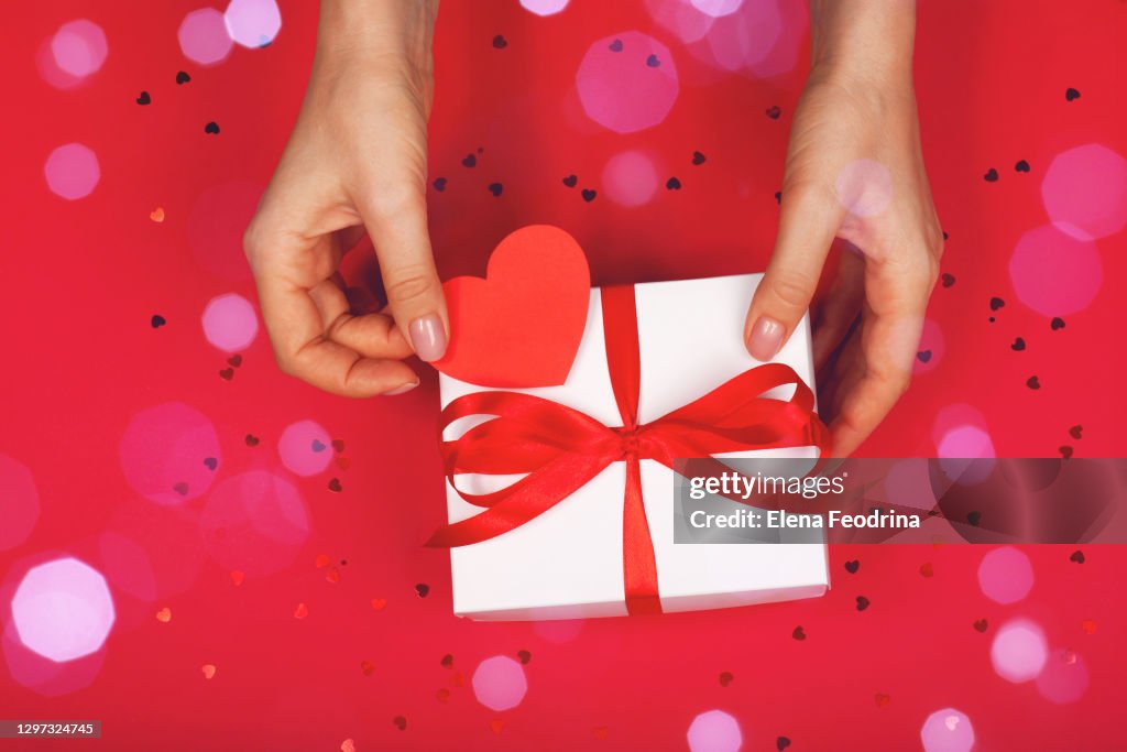 Beautiful female hand with packaged cute gift
