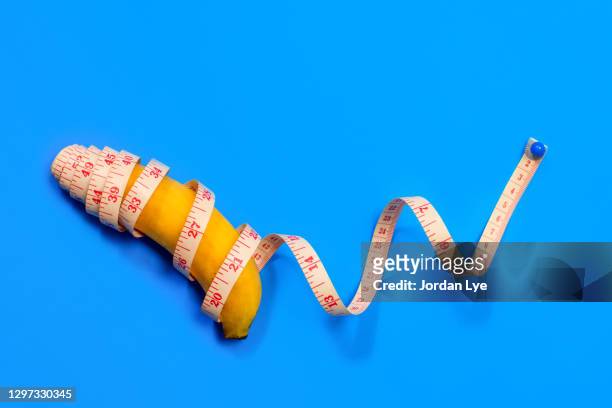 banana andmeasuring tape on blue background - length stock pictures, royalty-free photos & images