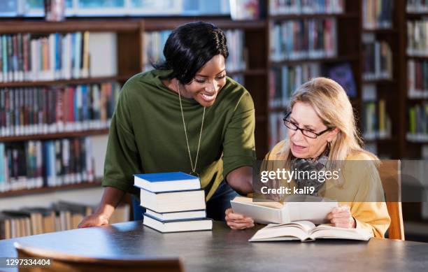 librarian helping senior with books - librarian stock pictures, royalty-free photos & images