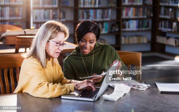 accountant helping young woman with budget or taxes - tax help stock pictures, royalty-free photos & images