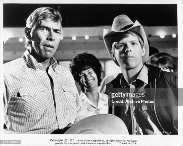 James Coburn is joined by his son Ted Eccles after a victorious day at the rodeo in a scene from the film 'The Honkers', 1972.