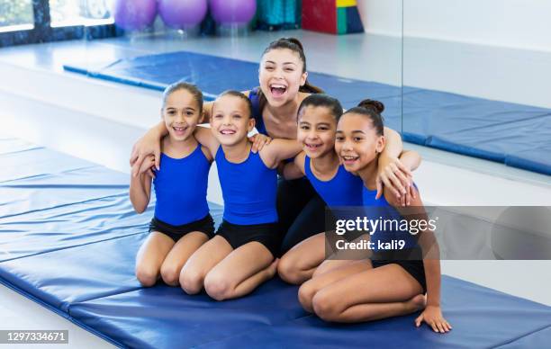 ジムで4人の女の子と体操コーチ - acrobat ストックフォトと画像