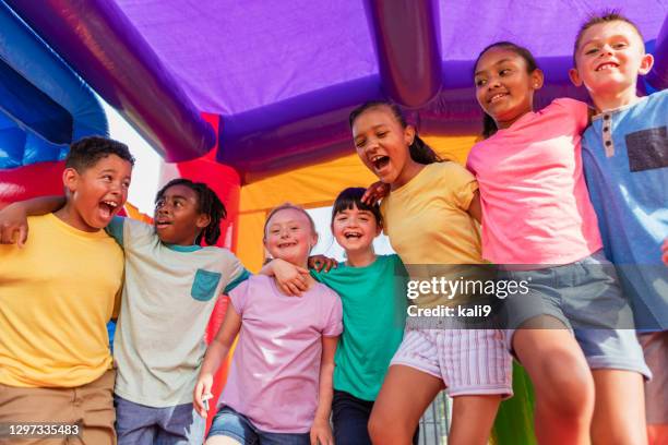 kinder im hüpfhaus, mädchen mit down-syndrom - inflatable playground stock-fotos und bilder