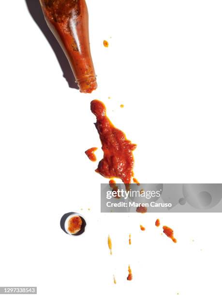 ketchup spilling from bottle - knoeien stockfoto's en -beelden