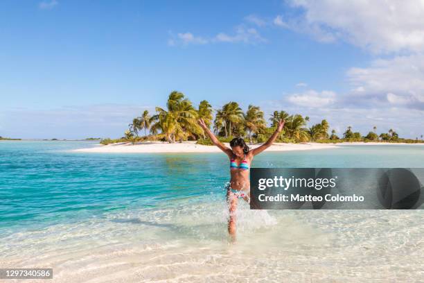 young woman in the blue lagoon on a tropical island - french polynesia stock-fotos und bilder