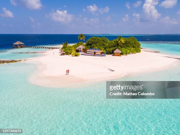 drone view of adult couple on a beach, maldives - insel stock-fotos und bilder