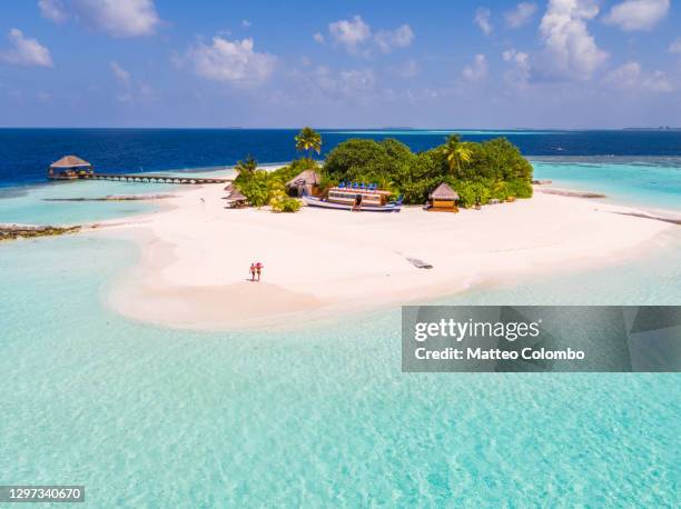 drone view of adult couple on a beach, maldives - oceano índico fotografías e imágenes de stock